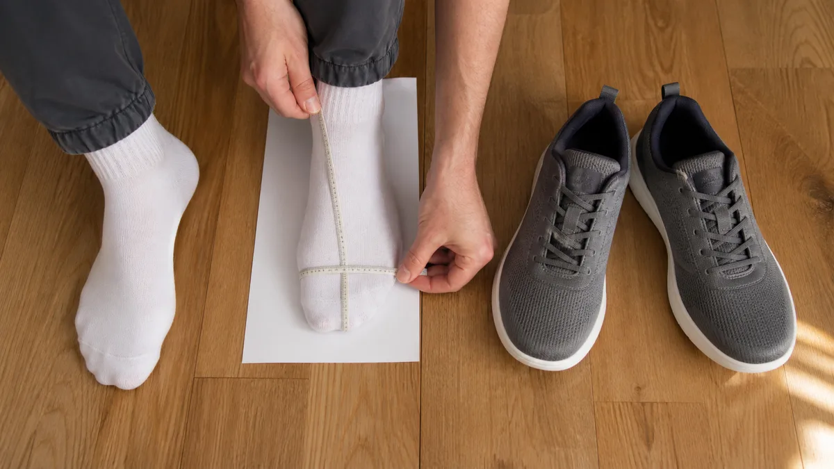 Measuring foot length and girth beside wide-toe trainers